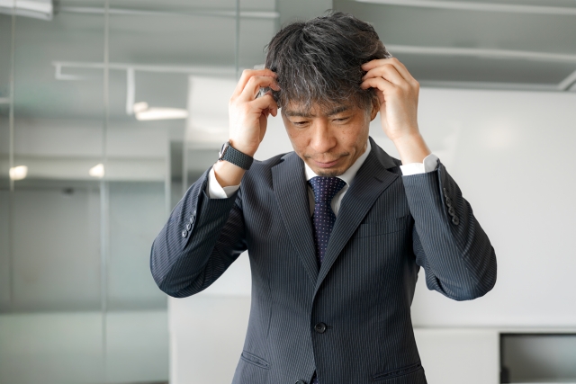 頭を抱えるビジネスマン